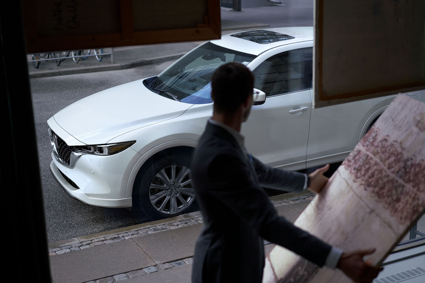 Quelqu'un qui observe une Mazda CX-5 turbo signature 2022 à travers une fenêtre