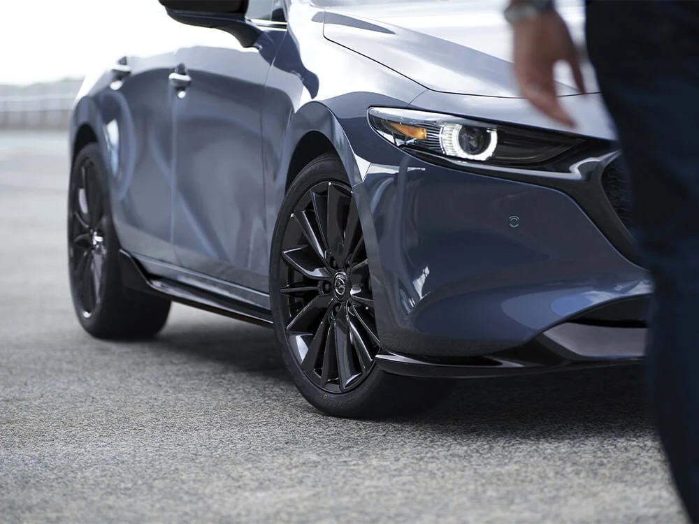 Vue partielle avant du Mazda3 Sport 2023 gris garé à l'extérieur