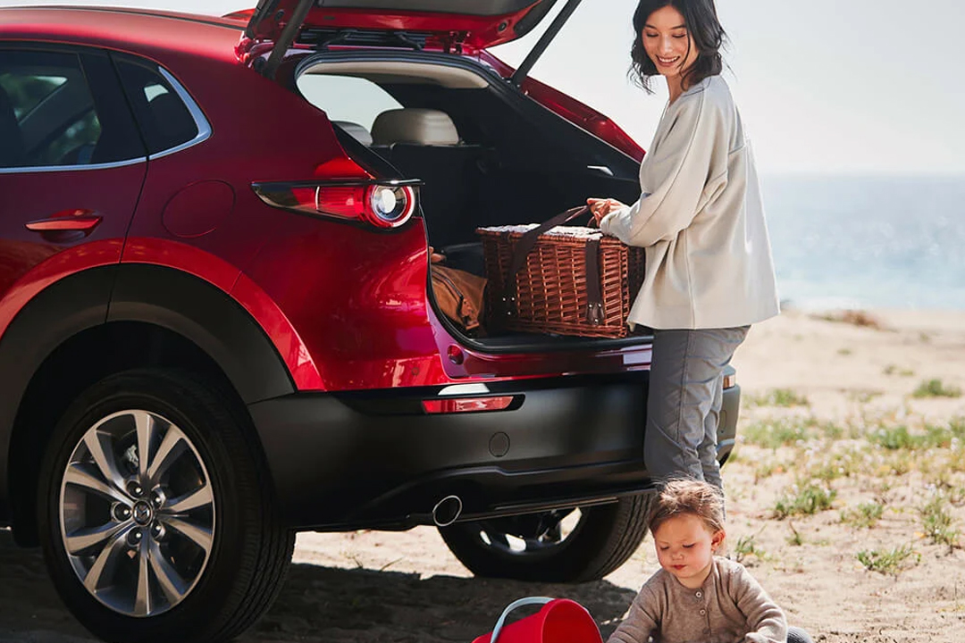 Vue du coffre du Mazda C5 avec famille a la plage