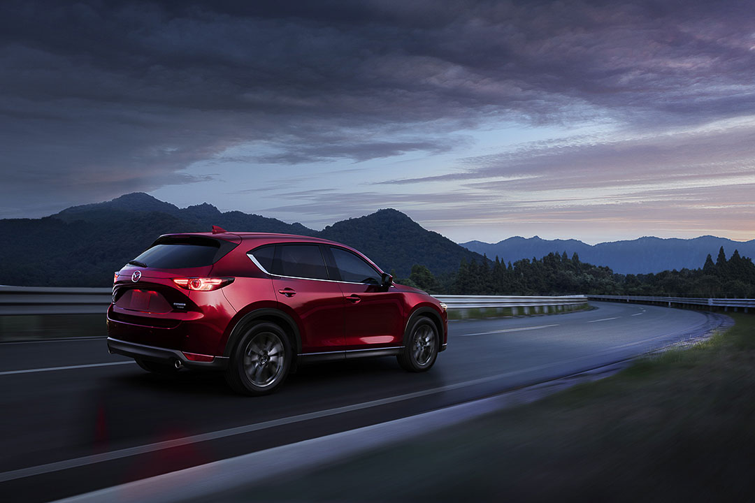 vue latérale arrière du Mazda CX-5 2021 roulant sur une autoroute au crépuscule