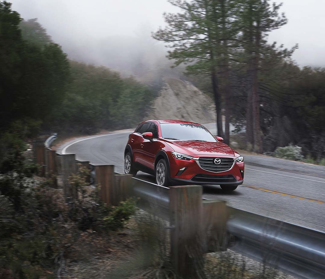 vue trois quart avant du Mazda CX-3 2021 roulant sur une route