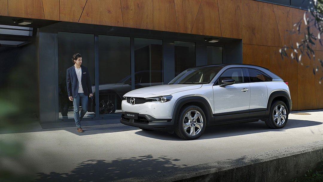 vue latérale avant du Mazda MX-30 2022 stationné devant une maison