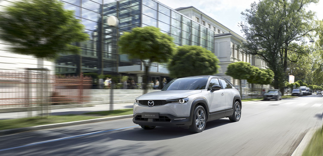 Vue 3/4 avant du Mazda MX 30 électrique 2022 roulant sur une rue en ville