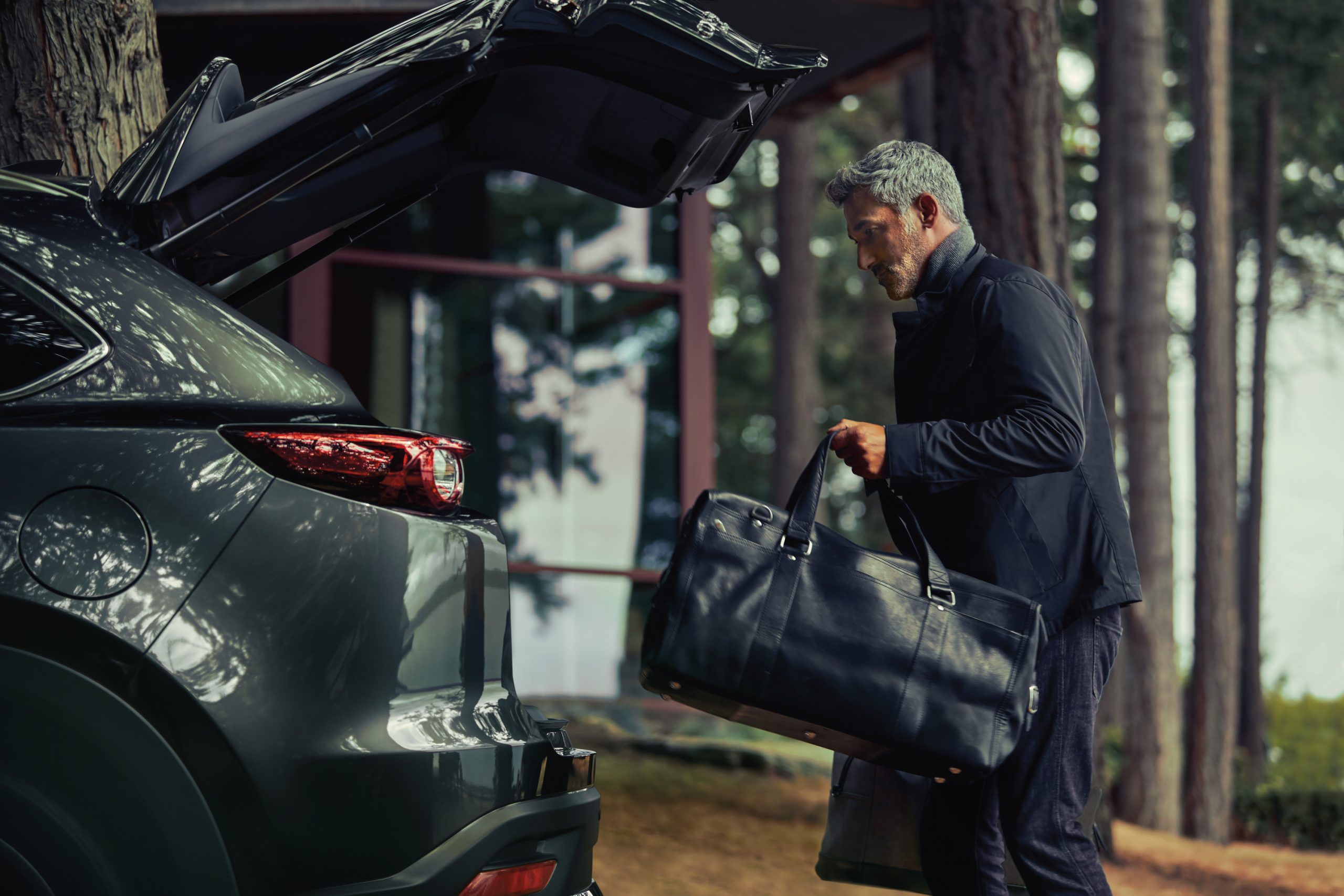 Père plaçant ses bagages dans le Mazda CX-9 2020